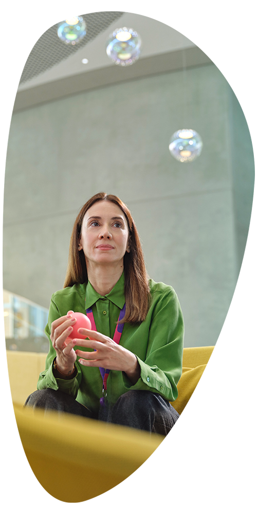 female EMD Serono employee, pondering possible solutions to a healthcare problem in a lounge area